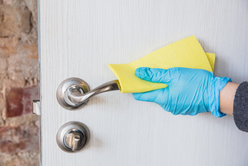 manos de persona con guantes limpian la cerradura como uno de los métodos caseros para evitar robos